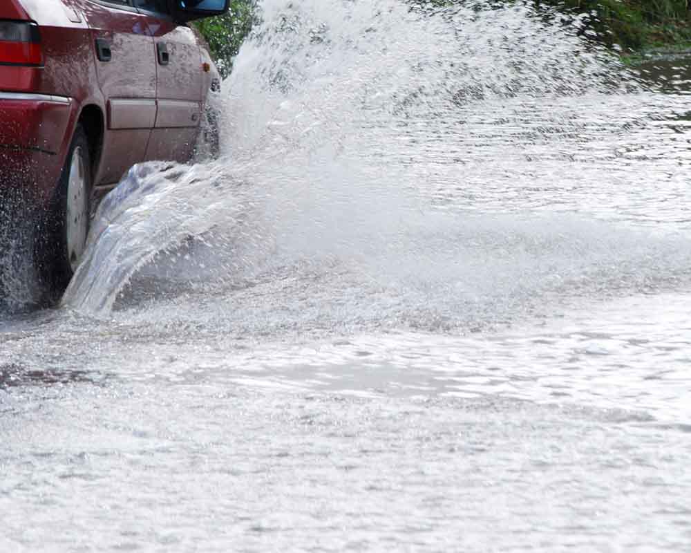 Car driving through flooded street - File Photo by JaneH