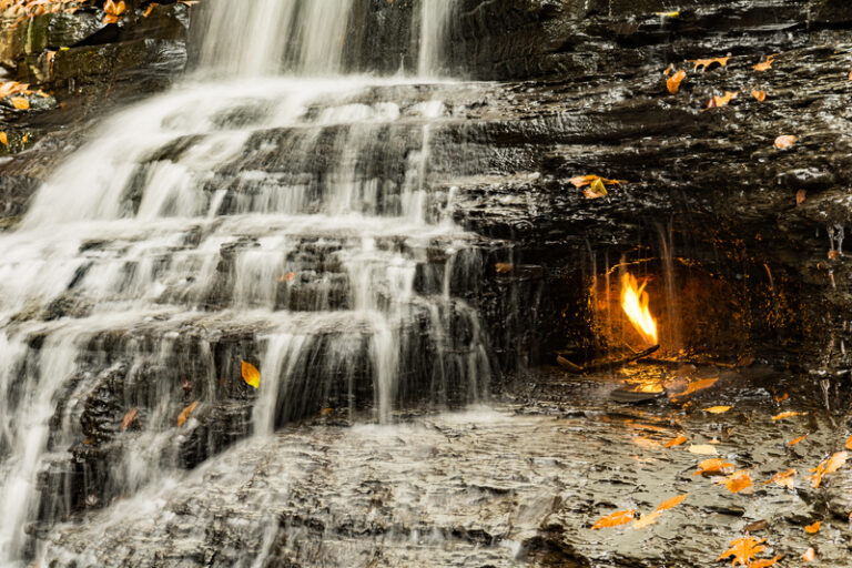A flame burns eternally and naturally under this new york state waterfall - photo licensed by shore news network.
