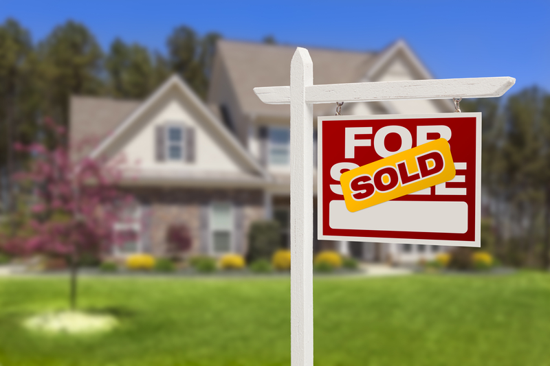 Sold Home For Sale Real Estate Sign in Front of Beautiful New House.