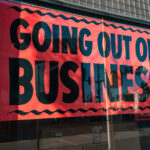 A Going Out of Business Sign in the display window of a commercial building