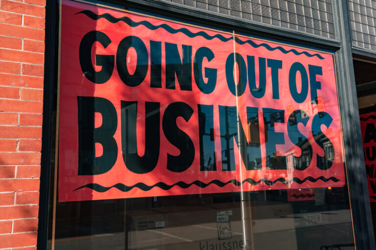 A going out of business sign in the display window of a commercial building