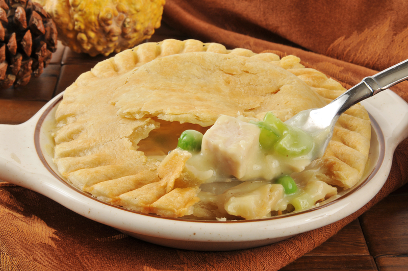 A forkful of turkey pot pie on a Thanksgiving type dinner table setting