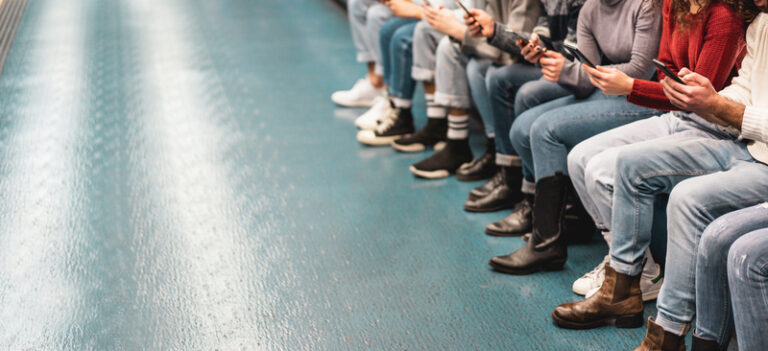 A-group-of-people-sit-while-checking-their-smart-phones