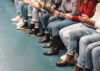 A-group-of-people-sit-while-checking-their-smart-phones