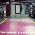 Electric car charging station in underground indoor parking of mall or office building. Reserved parking lot for environment
