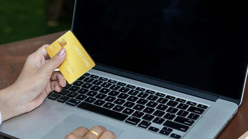 Plastic-credit-card-in-hand-and-use-of-laptop-for-internet-purchase