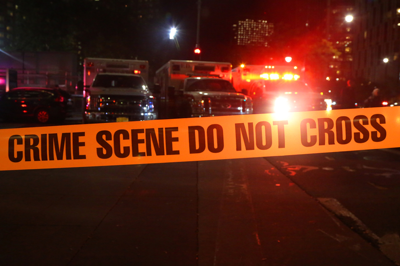 Police and Ambulances Behind Crime Scene Tape