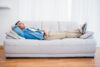 Smiling man lying and relaxing on the couch