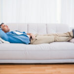 Smiling man lying and relaxing on the couch