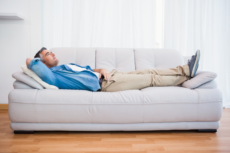 Smiling man lying and relaxing on the couch