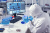 Doctor in medicine lab with petri dish dressed in coverall. Chemist in modern laboratory doing research