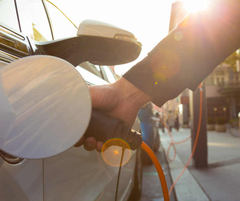 Ower supply for electric car charging. Electric car charging station. Close up of the power supply plugged into an electric car being charged.