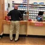 Customer inside a pharmacy shop pick up his prescription at a local Walgreens