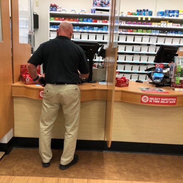 Customer inside a pharmacy shop pick up his prescription at a local walgreens