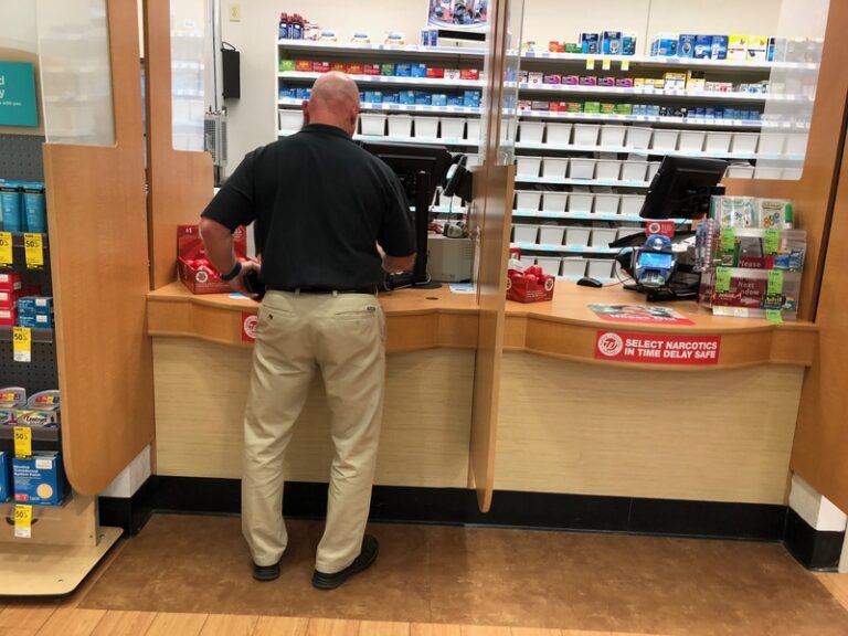 Customer inside a pharmacy shop pick up his prescription at a local walgreens