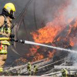 Firefighter-spray-water-on-tractor-trailer-burning