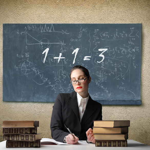 Portrait of a teacher sitting in front of a blackboard with a wrong addition written on it