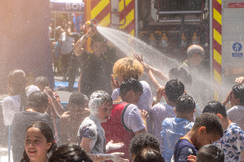 Kids cooling off on a hot day with help of firefighters - File Photo