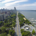 Cars ride by Henry Hudson Parkway near Riverside Park and 79th Street Boat Basin at summer sunny day. Aerial view