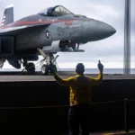 240928-N-DL824-2052 ATLANTIC OCEAN (Sept. 28, 2024) Aviation Boatswain's Mate (Aircraft Handling) 2nd Class Ronmel Quijano, a native of Miami, directs the transport of an F/A-18E Super Hornet, attached to the “Knighthawks” of Strike Fighter Squadron (VFA) 136, from the hangar bay to the flight deck aboard the Nimitz-class aircraft carrier USS Harry S. Truman (CVN 75), Sept. 28. Harry S. Truman, the flagship of the Harry S. Truman Carrier Strike Group