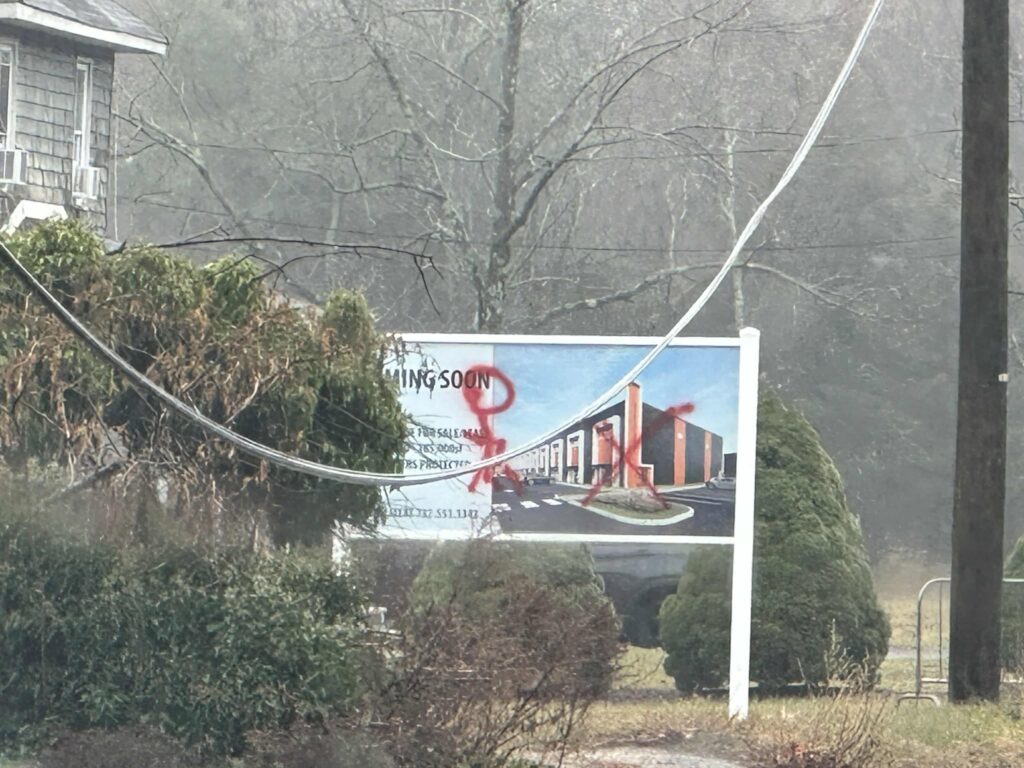 Vandal defaces warehouse construction sign with obscene graffiti in Jackson