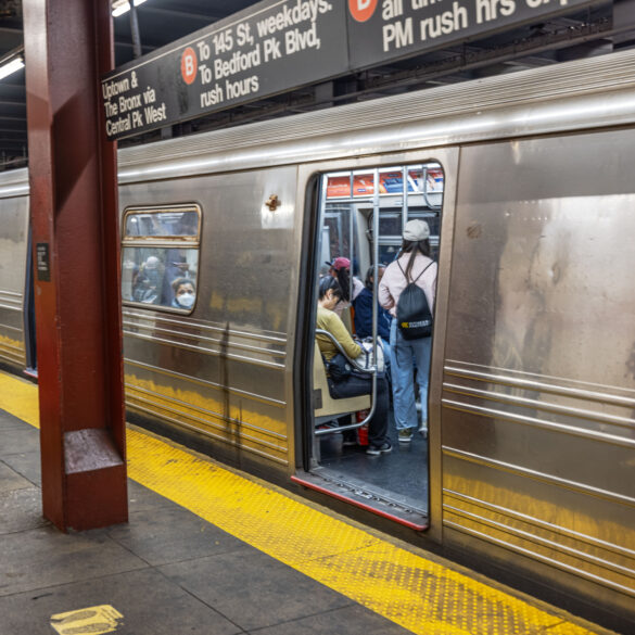 New york city subway station with passengers entering train, platform safety line and urban transit signage. New york. Usa.
