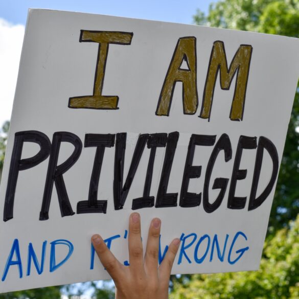A high school student holding up a sign that says i am privileged and it`s wrong to support black lives. Westfield, nj: 06/07/20: a high school student holding up a sign that says i am privileged and it`s wrong to support the black lives matter movement at a protest for george floyd`s death.