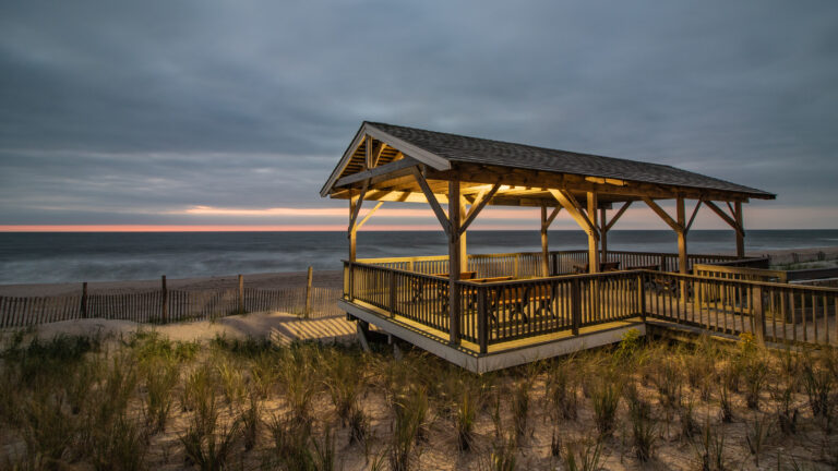 Sunrise at the pearl street pavilion in beach haven, nj. The pearl street pavilion on long beach island is still lit as sunrise peeks through morning clouds