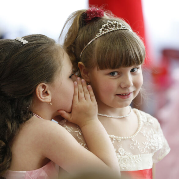 Girls whispering to each other.