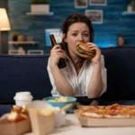 Single woman eating a hamburger - Photoshop/Generated/Satire