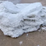 A chunk of ice lies on the beach. Similar chunks were reported this week along the delaware river in new jersey.