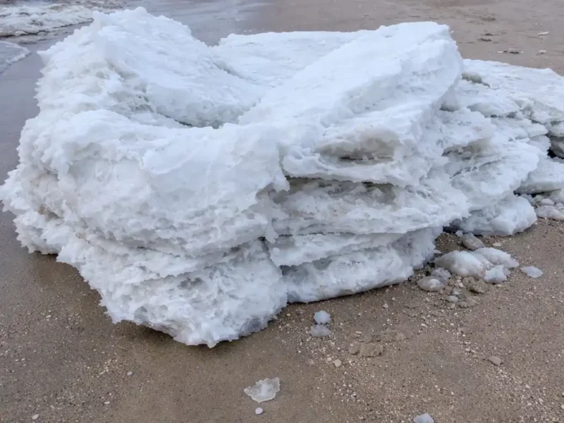 A chunk of ice lies on the beach. Similar chunks were reported this week along the delaware river in new jersey.