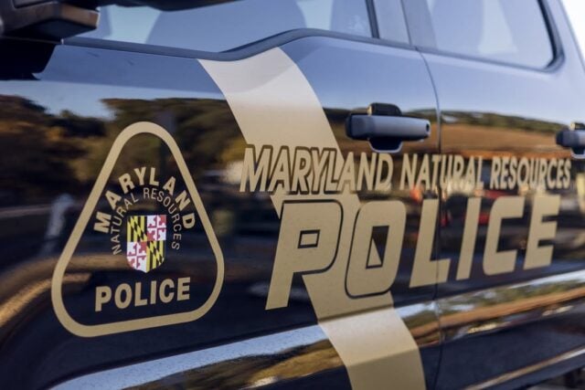 Maryland natural resources police car door with badge emblem and bold police lettering on a dark blue vehicle.