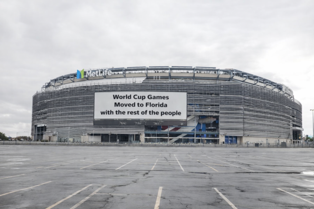 Metlife stadium exterior with a large billboard reading, "world cup games moved to florida with the rest of the people. "