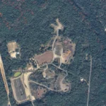 Aerial view of the Whiting Recycling Center in a forest, with winding access roads and labeled roads nearby.