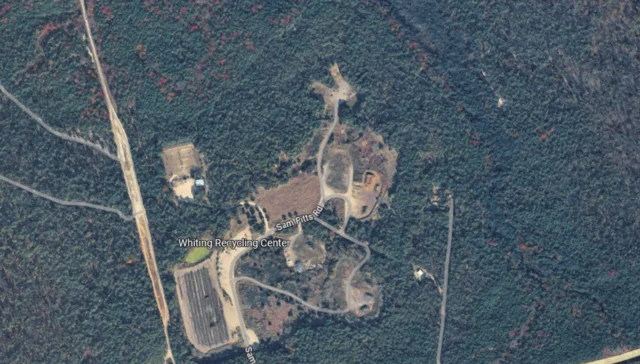 Aerial view of the whiting recycling center in a forest, with winding access roads and labeled roads nearby.