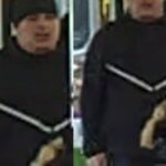 Two men in matching black outfits with white diagonal stripes ride a bus, one wearing a knit cap on the left and the other on the right.