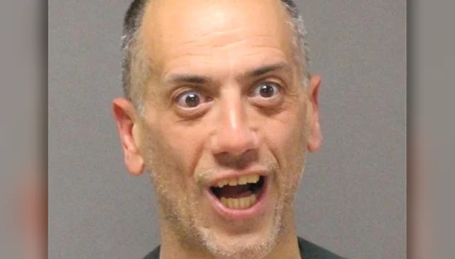 Man with wide eyes and open mouth in a mugshot-style photo, looking surprised or shocked.