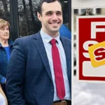 Smiling real estate agents and clients outside a house with a 'For Sale' sign and a yellow 'Sold' sticker.