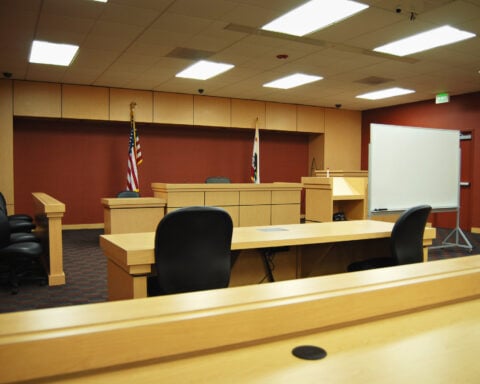 An empty courtroom awaiting trial - Photo by Nikolay Mamluke