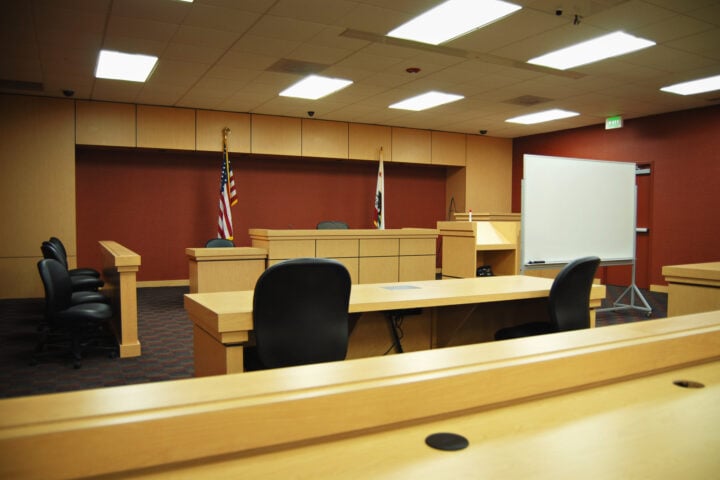 An empty courtroom awaiting trial - Photo by Nikolay Mamluke
