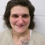 A Cumberland woman is being held without bond on arson and explosives charges after investigators said she intentionally set a July porch fire.