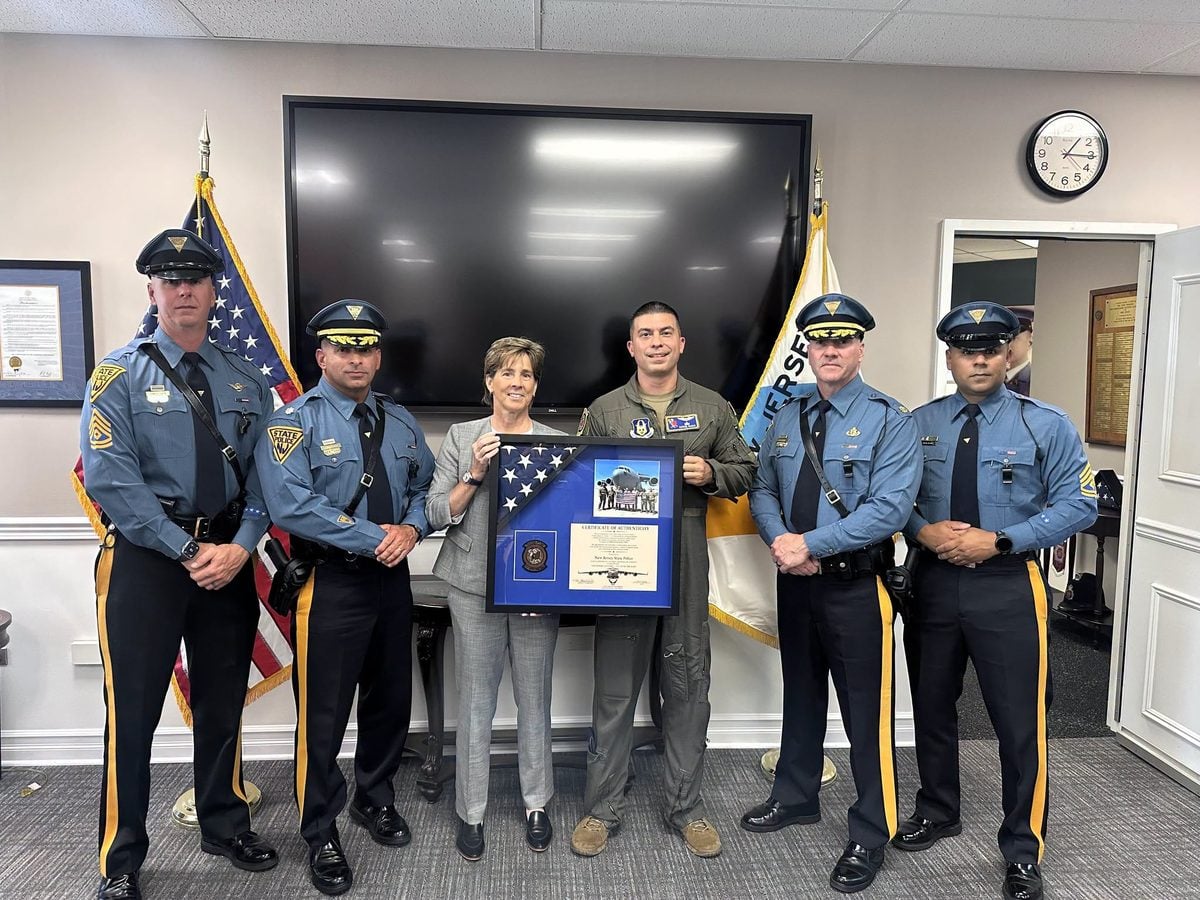 Trooper Vasco presents a framed American flag to the New Jersey State Police after returning from an overseas deployment as a C-17 pilot.