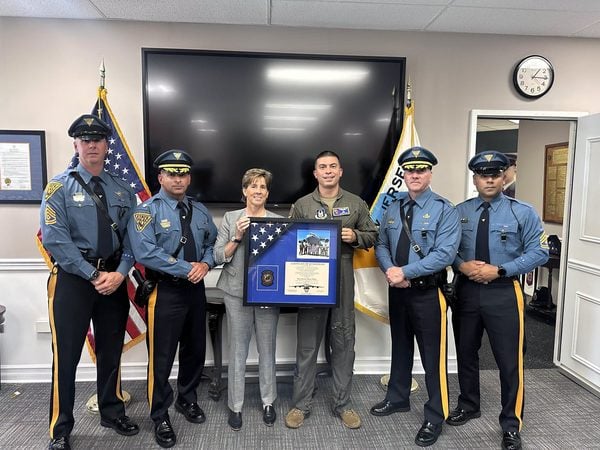 Trooper Vasco presents a framed American flag to the New Jersey State Police after returning from an overseas deployment as a C-17 pilot.