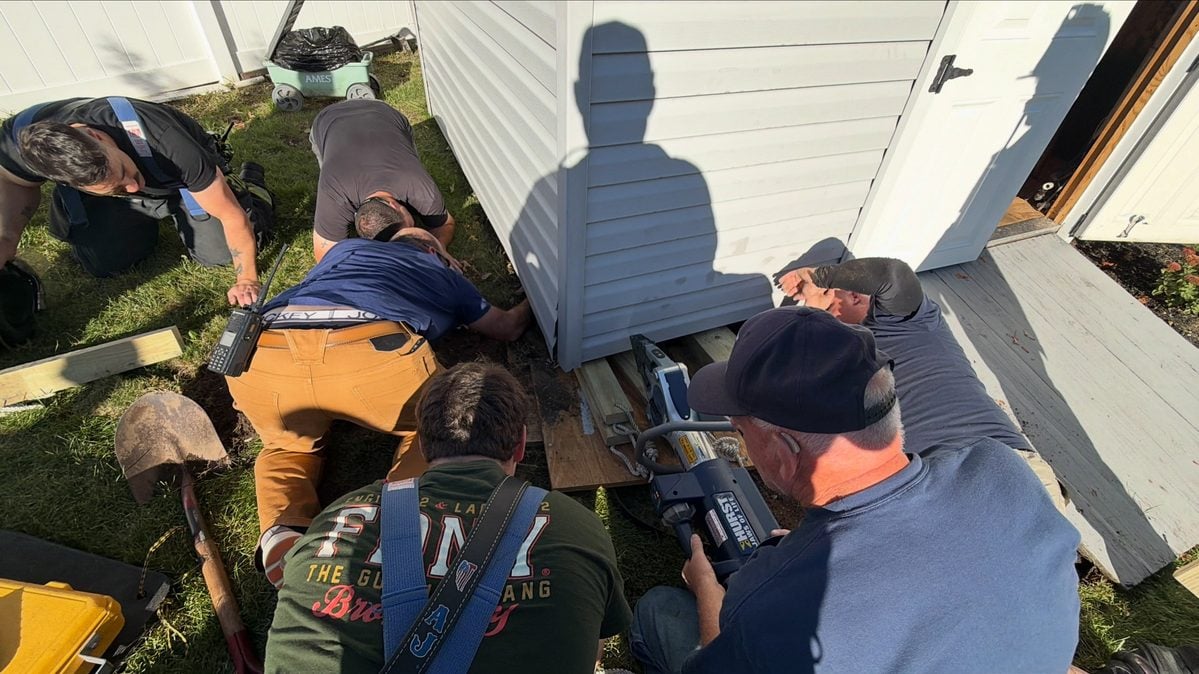Long island firefighters used the jaws of life to rescue cody, a frightened dog trapped beneath a backyard shed in bay shore, reuniting him with his family.