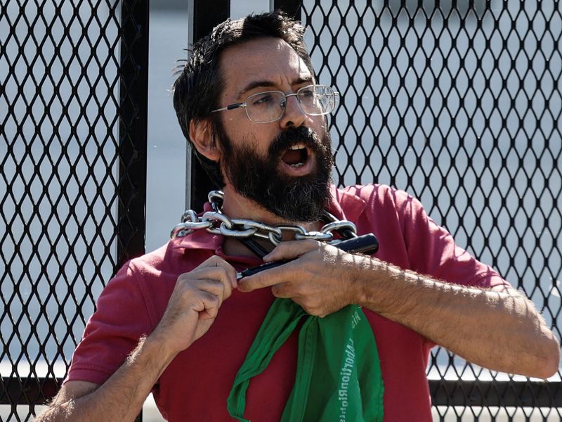 Abortion rights protester locks neck to U.S. Supreme Court fence