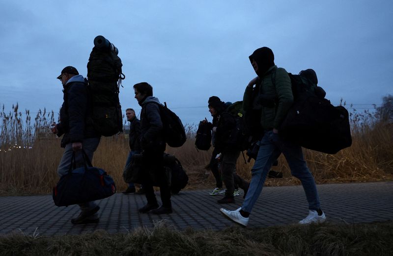 As Russia steps up assault, the fleeing fear for fathers left behind
