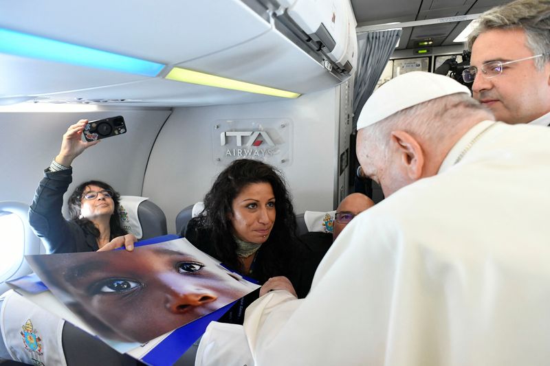 Pope Francis moved as Reuters photographer shows him child migrant picture