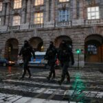 Members of the Police walk on the road following a