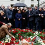 People hold a vigil to honour victims of Prague shooting